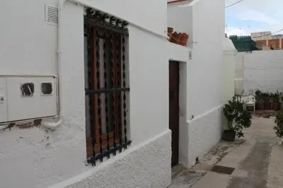 a white building with a gate on the side of it at Old Navy House in Badalona