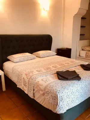 a bedroom with a large bed with a blanket at Casa les Pomeretes in El Figaró