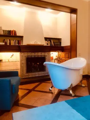 a bath tub in a living room with a fireplace at Casa les Pomeretes in El Figaró