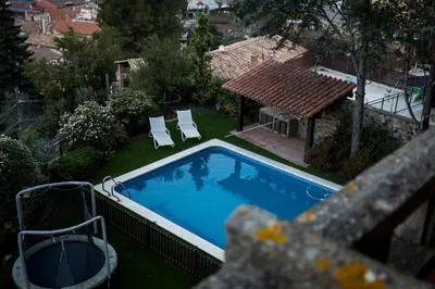 an overhead view of a swimming pool with two lawn chairs at Casa les Pomeretes in El Figaró