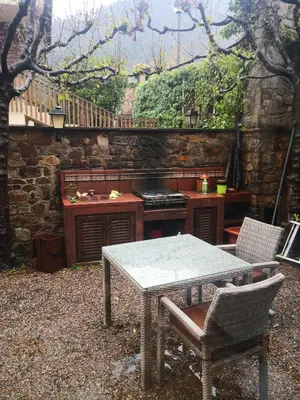 an outdoor kitchen with a table and a stove at Casa les Pomeretes in El Figaró