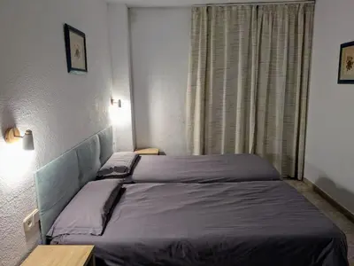a hotel room with two beds and a window at Apartamentos Mitus in Canet de Mar