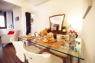 a dining room with a glass table and white chairs at Casa Tortilla Sagrada Familia in Barcelona