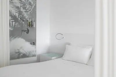 a white bedroom with a white bed and a window at Renaissance Barcelona Fira Hotel in Hospitalet de Llobregat