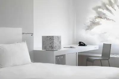 a bedroom with a bed and a desk with a phone at Renaissance Barcelona Fira Hotel in Hospitalet de Llobregat