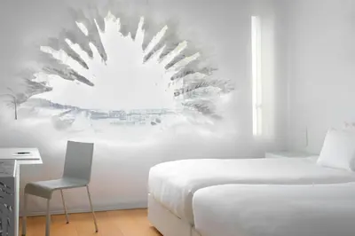 a bedroom with a bed and a desk and a chair at Renaissance Barcelona Fira Hotel in Hospitalet de Llobregat