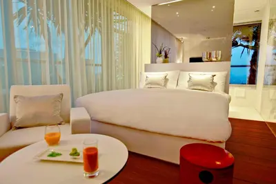 a bedroom with a large white bed and a table at Renaissance Barcelona Fira Hotel in Hospitalet de Llobregat