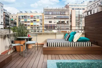 a bed on a balcony with a view of a city at Praktik Èssens in Barcelona