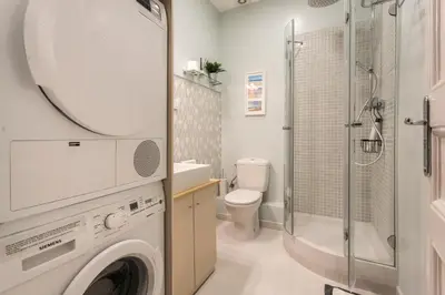 a bathroom with a washing machine and a shower at Luxury & Elegant Apartment in the centre in Barcelona