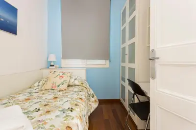 a small bedroom with a bed and a blue wall at Luxury & Elegant Apartment in the centre in Barcelona
