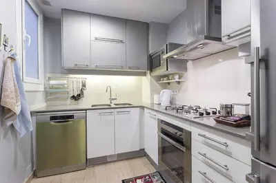 a kitchen with white cabinets and stainless steel appliances at Beautiful & Luxury Apartment centrally-located in Barcelona
