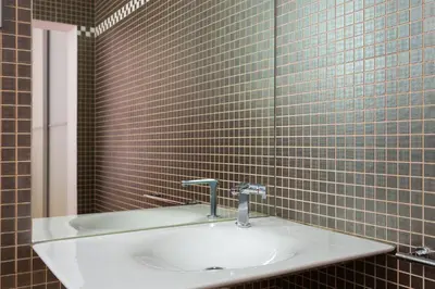 a bathroom with a sink and a tiled wall at Quartprimera Apartments in Barcelona
