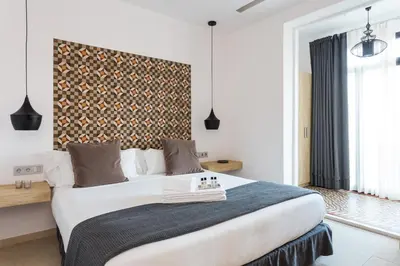a bedroom with a large white bed with a wall at Quartprimera Apartments in Barcelona