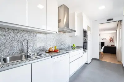 a kitchen with white cabinets and a sink at The Corner Apartments by Aspasios in Barcelona