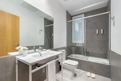 a bathroom with a sink and a toilet and a shower at The Corner Apartments by Aspasios in Barcelona