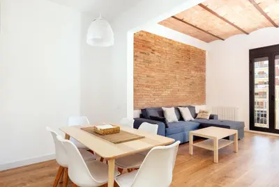 a living room with a table and a blue couch at Akira Flats Urgell apartment in Barcelona