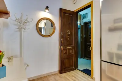a hallway with a wooden door and a mirror at Charming & Convenient Apartment Near Plaza Espanya in Barcelona
