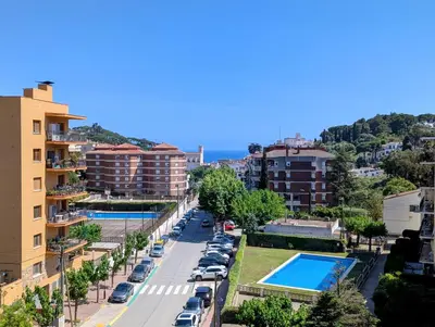 a street in a city with parked cars and buildings at Charming Attic with Pool and Seaviews in Arenys de Mar