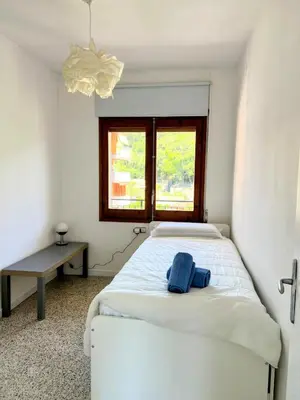 a bedroom with a white bed and a window at Charming Attic with Pool and Seaviews in Arenys de Mar