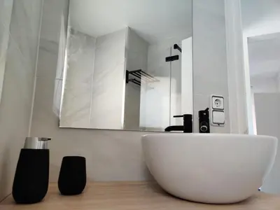 a bathroom with a white sink and a mirror at Charming Attic with Pool and Seaviews in Arenys de Mar