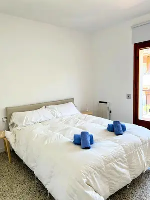 a white bed with two blue towels on it at Charming Attic with Pool and Seaviews in Arenys de Mar