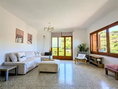 a living room with a couch and a table at Charming Attic with Pool and Seaviews in Arenys de Mar