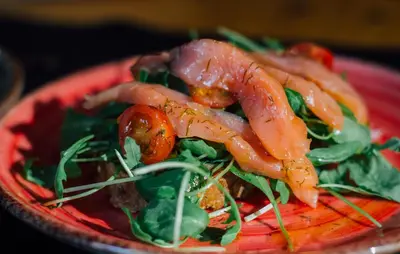 a red plate of food with shrimp on a salad at Bird House in Barcelona