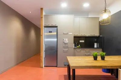 a kitchen with a stainless steel refrigerator and a wooden table at Bird House in Barcelona