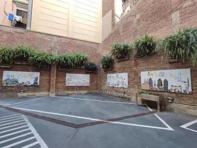 a basketball court in a parking lot next to a brick wall at Twentytu Hostel Barcelona in Barcelona