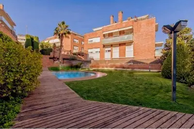 a backyard with a swimming pool in front of a building at Bonito duplex con piscina en Barcelona&playa in Tiana