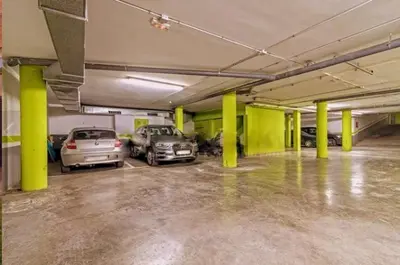 a parking garage with two cars parked in it at Bonito duplex con piscina en Barcelona&playa in Tiana