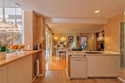 a large kitchen with white cabinets and a large window at Bonito duplex con piscina en Barcelona&playa in Tiana