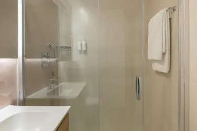 a bathroom with a glass shower and a sink at Cosmo Apartments Consell de Cent - Plaza Universitat in Barcelona