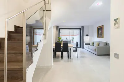 a dining room and living room with a staircase in a house at Cosmo Apartments Consell de Cent - Plaza Universitat in Barcelona
