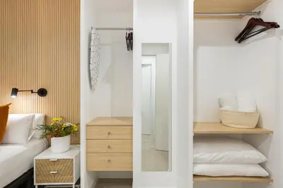a small bedroom with a bed and a mirror at Cosmo Apartments Consell de Cent - Plaza Universitat in Barcelona