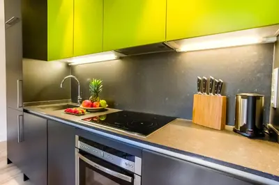 a kitchen with green cabinets and a stove top oven at Cosmo Apartments Passeig de Gràcia in Barcelona