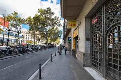 a couple of people walking down a sidewalk on a city street at SibsBcn COLISEUM - Cozy and Central in Barcelona