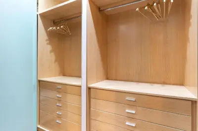 a walk in closet with wooden cabinets and drawers at SibsBcn COLISEUM - Cozy and Central in Barcelona