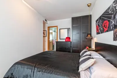 a bedroom with a large bed and a dresser at Cálido apartamento con piscina en Barcelona in Ripollet