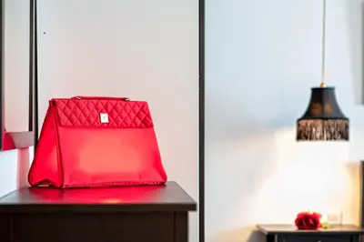 a red bag sitting on a table next to a lamp at Cálido apartamento con piscina en Barcelona in Ripollet