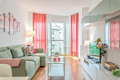 a living room with a couch and a tv at Cálido apartamento con piscina en Barcelona in Ripollet