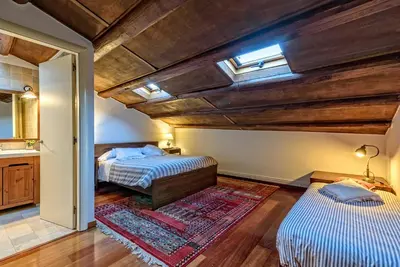 a bedroom with two beds and a bathroom with a window at Apartamento con encanto en Badalona in Badalona