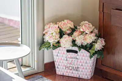 a vase filled with pink flowers next to a door at Apartamento con encanto en Badalona in Badalona