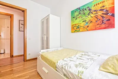 a bedroom with a bed and a painting on the wall at Apartamento lujo& piscina junto Barcelona Centro in Ripollet