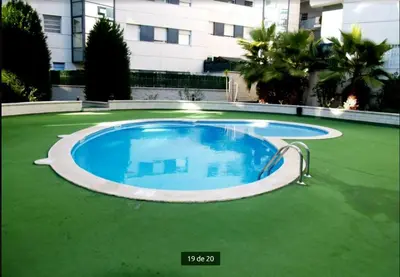a large swimming pool in the middle of a green lawn at Apartamento lujo& piscina junto Barcelona Centro in Ripollet