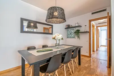 a dining room with a black table and chairs at Apartamento lujo& piscina junto Barcelona Centro in Ripollet