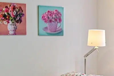 two pictures of flowers on a wall next to a lamp at Loft en Badalona Centro in Badalona