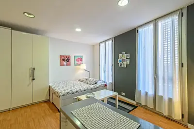 a room with a bed and a table and a window at Loft en Badalona Centro in Badalona