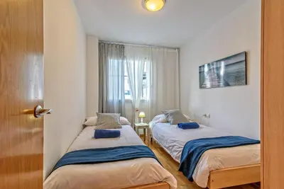 two beds in a small room with a window at Apartamento&piscina cerca de Barcelona in Ripollet