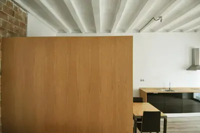 a dining room with a wooden partition and a table at Apartamento en Vilanova in Vilanova i la Geltrú